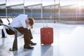 Depressed traveler waiting at airport after flights delays and cancellations