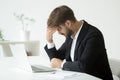 Depressed businessman shocked by bankruptcy failure sitting at w