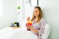 Sad woman eating ice cream in bed to feel better Royalty Free Stock Photo