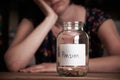 Depressed Woman Looking At Empty Jar Labelled Pension