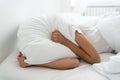 Depressed woman lying alone on bed covering head with pillow feeling afraid or depressed suffer from insomnia, loud sounds of Royalty Free Stock Photo