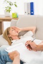 Depressed woman lying on couch and talking to therapist Royalty Free Stock Photo