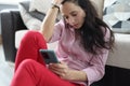 Depressed woman sits with closed eyes and holds smartphone in her hands. Royalty Free Stock Photo