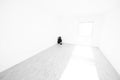 Depressed Woman Sitting on the Floor in a Corner in a Empty Room at Home