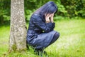 Depressed woman sitting near the tree in the park Royalty Free Stock Photo