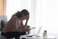 Depressed woman wearing glasses calculating bills, financial problem