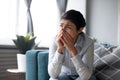 Depressed worried Indian woman crying alone, sitting on couch