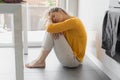 Depressed 30 years woman sitting on kitchen floor with hugging knees. Loneliness, sadness. Mental health, drug abuse and Royalty Free Stock Photo