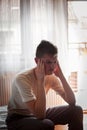 Depressed young boy is sitting in bed Royalty Free Stock Photo