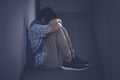 Depressed young boy sitting on the floor at school Royalty Free Stock Photo