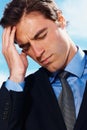 Depressed young business man with a bad head ache. Closeup of a depressed young business man with a bad head ache. Royalty Free Stock Photo