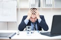 Depressed young business man holding his head Royalty Free Stock Photo