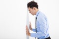 Depressed young business man leaning at the wall in office Royalty Free Stock Photo
