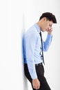 Depressed young businessman leaning at the wall in office Royalty Free Stock Photo