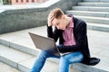 Depressed young handsome man sitting on stone stairs outdoors. Royalty Free Stock Photo