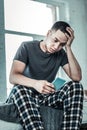 Depressed young man holding his smartphone in the hand Royalty Free Stock Photo