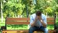 Depressed young man sitting alone bench thinking problem, broken heart, crisis Royalty Free Stock Photo