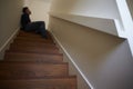 Depressed Young Man Sitting On Stairs At Home Royalty Free Stock Photo