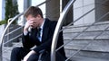 Depressed young man suit sitting stairs, unemployment problem, financial crisis