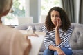 Depressed young woman having therapy with a psychologist