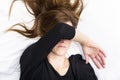 Depressed young woman is lying in her bed, covering her eyes. Royalty Free Stock Photo