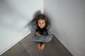 Depression feels so isolating. a depressed young woman sitting in a corner alone. Royalty Free Stock Photo