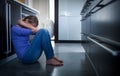 Depressed young woman, sitting on the kitchen floor Royalty Free Stock Photo