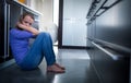 Depressed young woman, sitting on the kitchen floor, Royalty Free Stock Photo