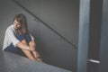 Depressed young woman sitting in a staircase Royalty Free Stock Photo