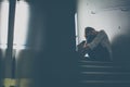 Depressed young woman sitting in a staircase, jobloss due to coronavirus pandemic Royalty Free Stock Photo