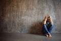 Depressing girl. Young beautiful blonde in a gray sweater and jeans Royalty Free Stock Photo