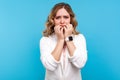 Depression and anxiety. Portrait of worried woman biting nails looking frightened terrified about problems. blue background