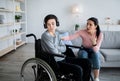 Depression in disabled teens. Sad adolescent in wheelchair shutting himself off from world, mother trying to talk to him Royalty Free Stock Photo