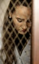 Depression, sadness and abuse with a woman behind a cage as a slave or prisoner of violence. Jail, prison and human Royalty Free Stock Photo