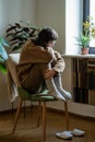 Lonely depressed teen girl hugging knees sitting alone on chair at home Royalty Free Stock Photo