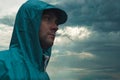 Depressive concept with lonely man in raincoat standing on wet road under rain close up Royalty Free Stock Photo