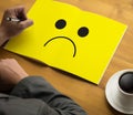 Depressive emotions concept, smiley face emoticon printed depr Royalty Free Stock Photo