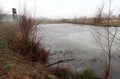 Depressive, ghostlike and foggy winters day in Czech nature. Panorama of a meadow with frosted pond in the foreground Royalty Free Stock Photo