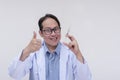 A deranged doctor making the thumbs up sign while eagerly holding a syringe and with an evil grin. Isolated on a white background Royalty Free Stock Photo