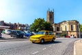 Yellow taxi car and Derby Cathedral in the background in Derby, UK Royalty Free Stock Photo