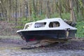 Derelict abandoned fibreglass boat on trailer dumped in waste ground Royalty Free Stock Photo