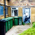 Derelict Building With a Row Of Wheely Bins Outside Royalty Free Stock Photo