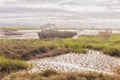 Derelict fishing boats on misty riverbanks