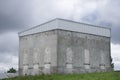 Derelict grey haunted building on hill which is an old power plant house