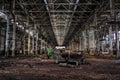 Derelict large dark industrial machinery hall of abandoned factory