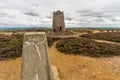 Trig post and derelict stone windmill, Parys Mountain. Royalty Free Stock Photo