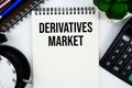 Derivatives Market text written on notepad with calculator and alarm clock Royalty Free Stock Photo