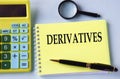DERIVATIVES - words in a notebook with a calculator, magnifying glass and pen in the background Royalty Free Stock Photo