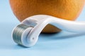 Derma roller for medical micro needling therapy with orange. Royalty Free Stock Photo