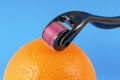 Derma roller for medical micro needling therapy with orange. Royalty Free Stock Photo